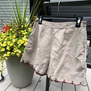 Small tan/grey shorts with maroon detail on the bottom